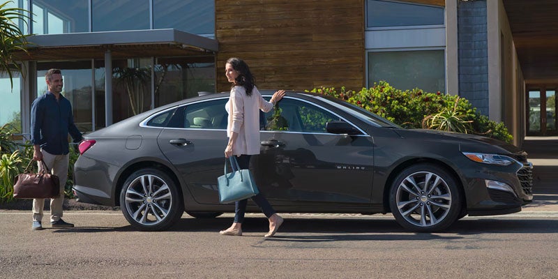 Woman standing next to 2025 Chevrolet Malibu
