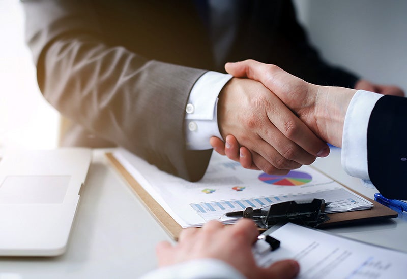 handshake over documents - Finnegan Chevrolet Buick GMC in Rosenberg TX